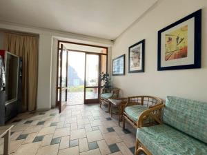 a living room with a couch and chairs and a television at Eden Appartamenti in Marina di Grosseto