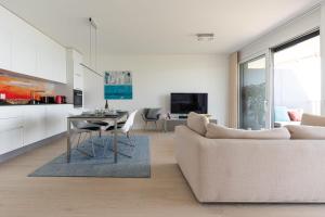 - un salon avec un canapé et une table dans l'établissement Les Terrasses de Lavaux 1 - Appartement de luxe avec vue panoramique et piscine, à Puidoux