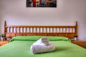 a green bed with a towel on top of it at Apartament Luisa in Lloret de Mar