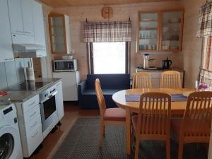 a kitchen and dining room with a table and chairs at LappHouse Puistola in Palojoensuu