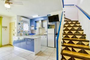 a kitchen with blue walls and a wooden wine rack at Apartamento Roses Victor in Roses +15 photos