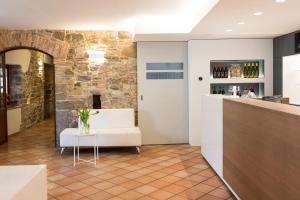 un bar con un divano bianco e un muro di pietra di Hotel Locanda Al Pomo d'Oro a Cividale del Friuli