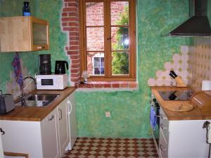 a small kitchen with a sink and a microwave at Fischerhaus Godewind 45 qm Studio in Altwarp