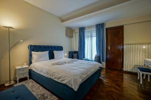 Schlafzimmer mit einem großen Bett mit blauem Kopfteil in der Unterkunft LOVELY - 3 BDR. SERVICED APARTMENT IN OLD TOWN in Bukarest