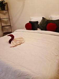 Una cama blanca con almohadas negras y rojas y una escalera. en Suite MaryMe, en Stains