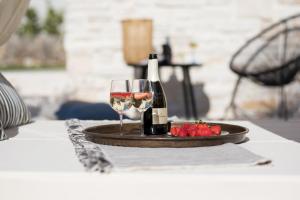 a table with two glasses of wine and a plate of strawberries at Villa Luna in Županje