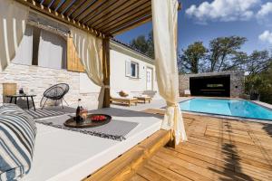 a patio with a swimming pool and a deck with a table at Villa Luna in Županje