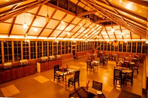 a restaurant with tables and chairs in a room at Southern Panorama Campnoel Munnar in Vattavada