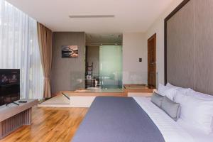 een slaapkamer met een groot bed en een woonkamer bij Sky View Luxury Pool Villa - SHA in Suratthani
