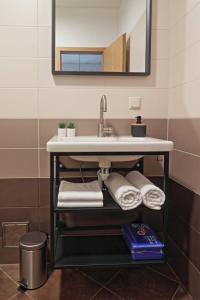 een badkamer met een wastafel, handdoeken en een spiegel bij Apartman Studio Pesja in Omišalj