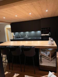 una cucina con bancone in legno e sgabelli da bar di WEF luxury living a Klosters