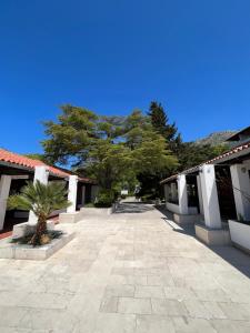 a courtyard of a building with a tree in the distance at Aparthotel Plat in Mlini