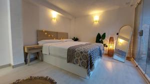 sypialnia z dużym łóżkiem i lustrem w obiekcie New Boho Home with Balcony, Private Garden and Communal Pool w mieście Nerja +28 zdjęć