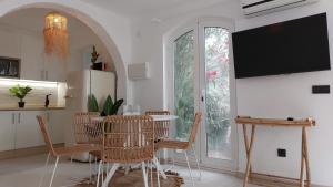 kuchnia ze stołem, krzesłami i telewizorem w obiekcie New Boho Home with Balcony, Private Garden and Communal Pool w mieście Nerja