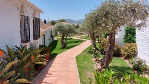 ceglany chodnik obok domu z drzewami w obiekcie New Boho Home with Balcony, Private Garden and Communal Pool w mieście Nerja