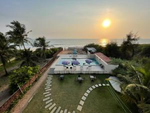 an aerial view of a house with a pool and the ocean at Kay's By The Sea in Ajgaon