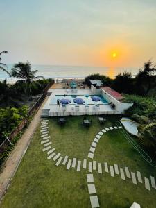 an aerial view of a resort with a pool and the ocean at Kay's By The Sea in Ajgaon