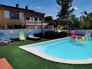 a swimming pool with a toy flamingo in a backyard at La maison d'Hôtes Du Moulin in Lagardelle-sur-Lèze