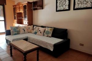 ein Wohnzimmer mit einem Sofa und einem Tisch in der Unterkunft Apartamento para 6 personas en Barbastro in Barbastro
