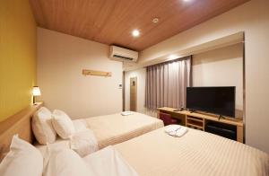 Postel nebo postele na pokoji v ubytování Sotetsu Fresa Inn Tokyo Tamachi