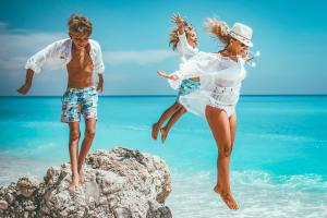 two people jumping on rocks at the beach at Pieno Centro Apartment in Tropea