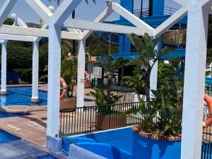 una piscina en el complejo con agua azul y plantas en BENALBEACH LOFT Encatador en Benalmádena