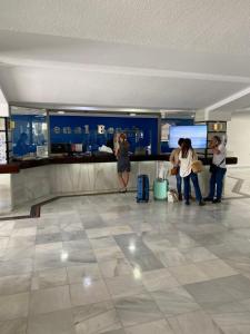 un grupo de personas esperando su equipaje en un aeropuerto en BENALBEACH LOFT Encatador en Benalmádena