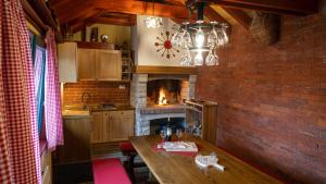 a kitchen with a fireplace and a wooden table at Chalets Runolist in Crni Lug
