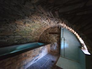 eine Badewanne in einer Ziegelwand mit einem Fenster in der Unterkunft Albergo Diffuso Ca' Spiga in Laglio