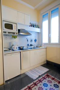 a kitchen with white cabinets and a microwave at Casa Palacio López Daza in Granada