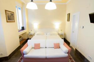 a bedroom with two beds and a couch at Casa Palacio López Daza in Granada