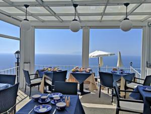 ein Restaurant mit blauen Tischen und Stühlen auf einem Balkon in der Unterkunft Vista Mare BB in Anacapri
