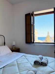 a bedroom with a bed with a view of the ocean at Ritsos Family Apartment in Monemvasia