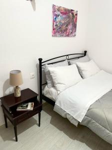 een slaapkamer met een bed en een tafel met een lamp bij Ritsos Family Apartment in Monemvasia