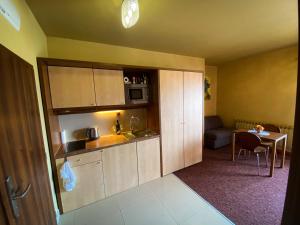 eine Küche mit weißen Schränken und einem Tisch im Zimmer in der Unterkunft Apartmán Mountain View - Tatragolf C in Veľká Lomnica