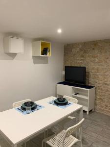 een woonkamer met een witte tafel en een tv bij Locazione Santa Rita in Molfetta