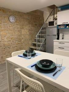 een keuken met een tafel met borden en glazen erop bij Locazione Santa Rita in Molfetta