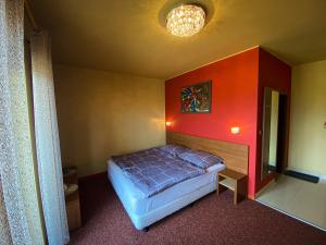 ein Schlafzimmer mit einem Bett und einer roten Wand in der Unterkunft Apartmán Mountain View - Tatragolf C in Veľká Lomnica