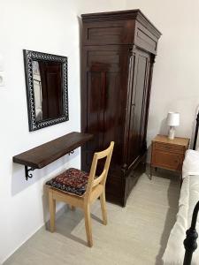 a bedroom with a bench and a chair and a mirror at Ritsos Family Apartment in Monemvasia