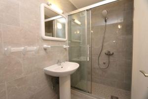 łazienka z umywalką i przeszkloną kabiną prysznicową w obiekcie Apartment Silo 35 w mieście Šilo +15 zdjęć