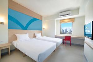 a hotel room with two beds and a tv at Hop Inn Hotel Cebu City in Cebu City