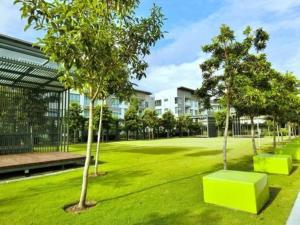 a green park with trees and a building at THE LOFT RESIDENCES HOMESTAY @ BLOCK C IMAGO MALL KK CENTRAL in Kota Kinabalu