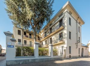 een appartementencomplex met een boom ervoor bij L'Antico Cedro Apartment in Alba