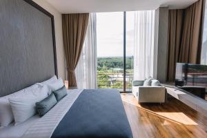 een slaapkamer met een bed en een groot raam bij Sky View Luxury Pool Villa - SHA in Suratthani