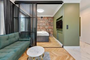 a living room with a green couch and a bed at Downtown Apartments Old Town Grobla I in Gdańsk