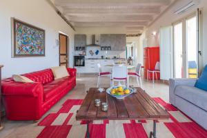 Una sala de estar con un sofá rojo y una mesa. en Casale dei Cactus, en Noto