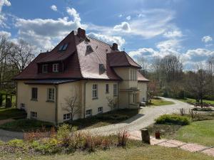una grande casa con tetto marrone di Gästezimmer in herrschaftlicher Villa a Krakow am See