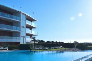 a swimming pool in front of a hotel at Agua Hotels Riverside in Ferragudo