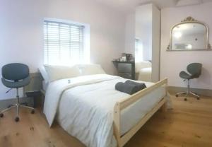 um quarto com uma cama com 2 cadeiras e um espelho em Buck - En-suite Room in Canalside Guesthouse em Burnley