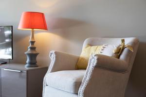 lampa siedząca obok krzesła obok telewizora w obiekcie DOMAINE DES ROSES AP4222 by Riviera Holiday Homes w Nicei